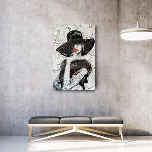 Pu&ograve; includere: Opera d'arte a tecnica mista raffigurante una donna con un grande cappello nero e rossetto rosso. L'opera &egrave; composta da giornali e ritagli di riviste sovrapposti. La parola "Style" &egrave; visibile.
