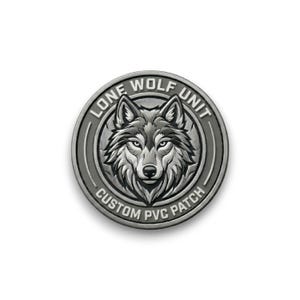 May include: A circular, silver-colored patch featuring a detailed wolf's head in the center. The text "LONE WOLF UNIT" arches above the wolf, and "CUSTOM PVC PATCH" curves below. The design has a raised, textured appearance.