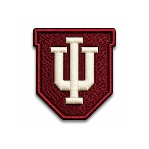 May include: A maroon and cream embroidered patch featuring the Indiana University logo. The logo is a stylized letter "I" with a "U" shape in the center. The patch has a stitched border and a shield shape.