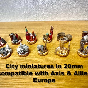 May include: A set of miniature city landmarks, such as the Eiffel Tower and Big Ben. The miniatures are approximately 2 cm in size and are designed for use with Axis & Allies Europe. The image includes text that reads "City miniatures in 20mm compatible with Axis & Allies Europe."