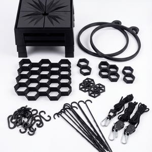 May include: A collection of black 3D-printed components, including a square base with a starburst design, two circular rings, a honeycomb grid, various geometric shapes, hooks, and rope with adjustable hangers. The items are arranged on a white surface.