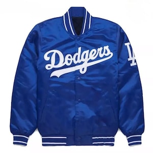 May include: A royal blue satin jacket featuring the word "Dodgers" in white script across the chest and the letter "L" on the right sleeve. The jacket has a white collar, cuffs, and hem with blue stripes. A classic baseball team jacket.