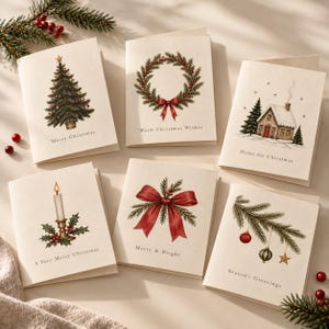 May include: A set of six cream-colored greeting cards featuring watercolor illustrations of Christmas themes including a tree, wreath, cottage, candle, red bow, and ornaments, each with printed text such as Merry Christmas and Season's Greetings.