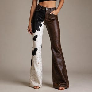 May include: High-waisted flared trousers featuring a split-leg design. The left leg displays a black and white cow print pattern with a textured finish, while the right leg is a solid dark brown with a smooth, leather-like appearance and visible stitching.