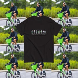 Può includere: T-shirt nero con la scritta "PUT A BELL ON YOUR BICYCLE" e una grafica di ciclisti. L'immagine mostra anche una persona che guida una bici Lime con un cestino verde.