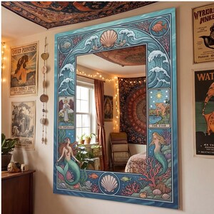 May include: A large, rectangular mirror with a blue, ocean-themed border. The border features waves, seashells, fish, and mermaids. The mirror's design incorporates tarot card imagery, creating a whimsical and artistic aesthetic.