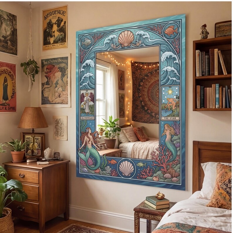 May include: Large rectangular mirror with a blue frame featuring a mermaid and ocean-themed design. The frame includes illustrations of waves, seashells, and fish. The mirror is hanging on a wall in a bedroom with bohemian decor.