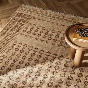 Naturbeige ullmatta i jute: Handvävd texturerad plattväv med jordiga bruna geometriska folkmotiv