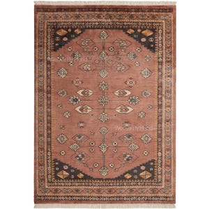May include: A rectangular area rug in shades of terracotta and dark charcoal, featuring a central vertical floral motif with symmetrical geometric patterns. The border displays intricate repeating designs, and the rug ends in a cream-colored fringe.