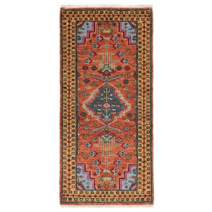 May include: A rectangular, hand-knotted rug with a central design in shades of orange, teal, and blue. The rug features geometric patterns and a border with repeating motifs in yellow, red, and blue. The rug has a fringed edge.