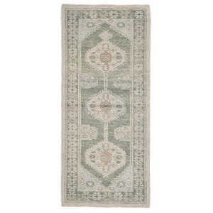 Peut inclure: Un tapis rectangulaire à motifs avec un motif central dans des tons de vert, beige et rouille. Le tapis présente un motif géométrique symétrique avec des motifs floraux et de médaillons. La bordure est de couleur beige clair.