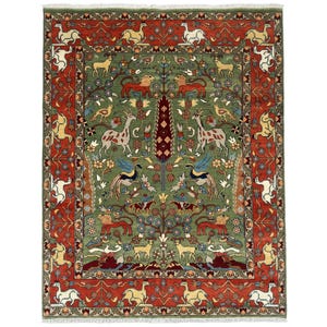 May include: A rectangular, hand-knotted rug with a central green field and a red border. The rug features a detailed pattern of animals, including deer, lions, and birds, along with floral and tree motifs. The design is symmetrical and intricate, with a fringe along the edges.