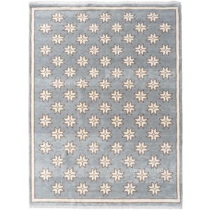 May include: A rectangular area rug featuring a light blue background with a repeating pattern of cream-colored eight-pointed stars. The rug is framed by a thin cream border and includes a short fringe along the top and bottom edges.