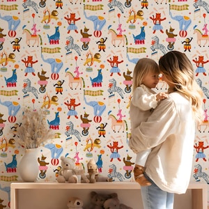 May include: A whimsical wallpaper featuring a repeating circus-themed pattern. The design includes colorful illustrations of elephants, zebras, lions, monkeys, and tigers performing circus acts. The background is a cream color, and the overall style is playful and vibrant.