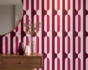 May include: Wallpaper featuring a repeating pattern of vertical stripes with alternating dark maroon and light pink elongated oval shapes. A wooden console table sits in front of the wall with two small vases and a clear glass vase with dried stems.