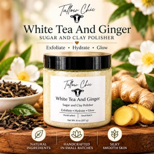 Könnte beinhalten: Ein durchsichtiger Tiegel Tallow Chic White Tea And Ginger Sugar and Clay Polisher mit schwarzem Deckel. Das Etikett zeigt ein Kuh-Symbol, den Text Exfoliate, Hydrate, Glow und Net Wt. 8 oz (227 g). Das Produkt ist von Teeblättern und Ingwer umgeben.