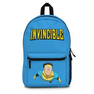 May include: A bright blue backpack featuring the word INVINCIBLE in bold yellow letters at the top. Below the text, a graphic illustration shows a character with dark hair, yellow goggles, and a blue and yellow suit flying forward.