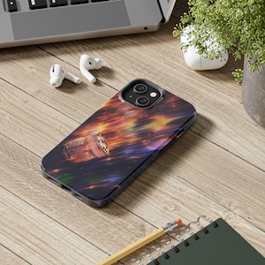 以下が含まれることがあります： カラフルな宇宙をテーマにしたデザインの黒いiPhoneケース。ケースは、オレンジ、黄色、紫の色合いが鮮やかに混ざり合い、宇宙船の詳細なイラストが描かれています。ケースは木製の表面にあります。