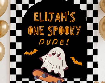 Puede incluir: Un tapiz rectangular con un borde de cuadros blancos y negros que rodea un arco negro. El texto ELIJAH'S ONE SPOOKY DUDE! aparece en letras naranjas sobre un fantasma de dibujos animados en un monopatín naranja con dos murciélagos.