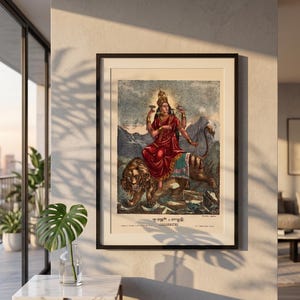 May include: Framed vintage print of a deity riding a lion. The deity is depicted in a red garment with multiple arms, adorned with a golden crown. The lion is brown and tan, set against a backdrop of mountains and text at the bottom.