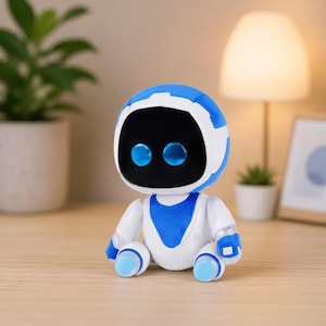 以下が含まれることがあります： 丸みを帯びた頭と体を持つ、白と青の小さなロボットのおもちゃ。 ロボットは、2つの青い光る目を持つ黒い顔をしています。 木の表面に座っており、背景にはランプと植物があります。