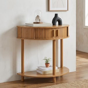 May include: A semi-circular wooden console table featuring a tambour-style slatted front drawer with two vertical wooden handles. The table has a lower shelf, four cylindrical legs, and a light brown wood grain finish throughout the structure.
