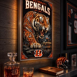 May include: A rectangular wall art piece featuring a snarling tiger with orange and black filigree patterns, the text Cincinnati Bengals Est. 1967, and a city skyline. Below, a glass decanter, a tumbler, a leather journal, and a football helmet.