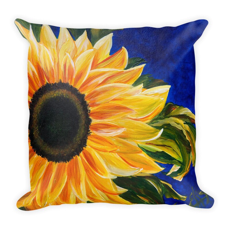 May include: A close-up of a sunflower with yellow petals and a dark brown center. The sunflower is painted on a blue background.