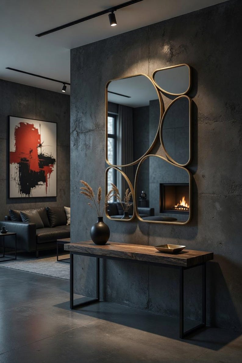 May include: A modern interior featuring a large, multi-paneled gold-framed mirror. Below the mirror is a dark wood console table with a black metal frame. A black vase with dried plants sits on the table. A painting with red and black brushstrokes hangs on the wall.