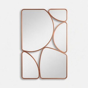 May include: A modern wall mirror with a unique design. It features multiple irregularly shaped mirrors with copper-colored frames. The arrangement includes a half-circle, rectangles, and other geometric forms, creating a contemporary aesthetic.