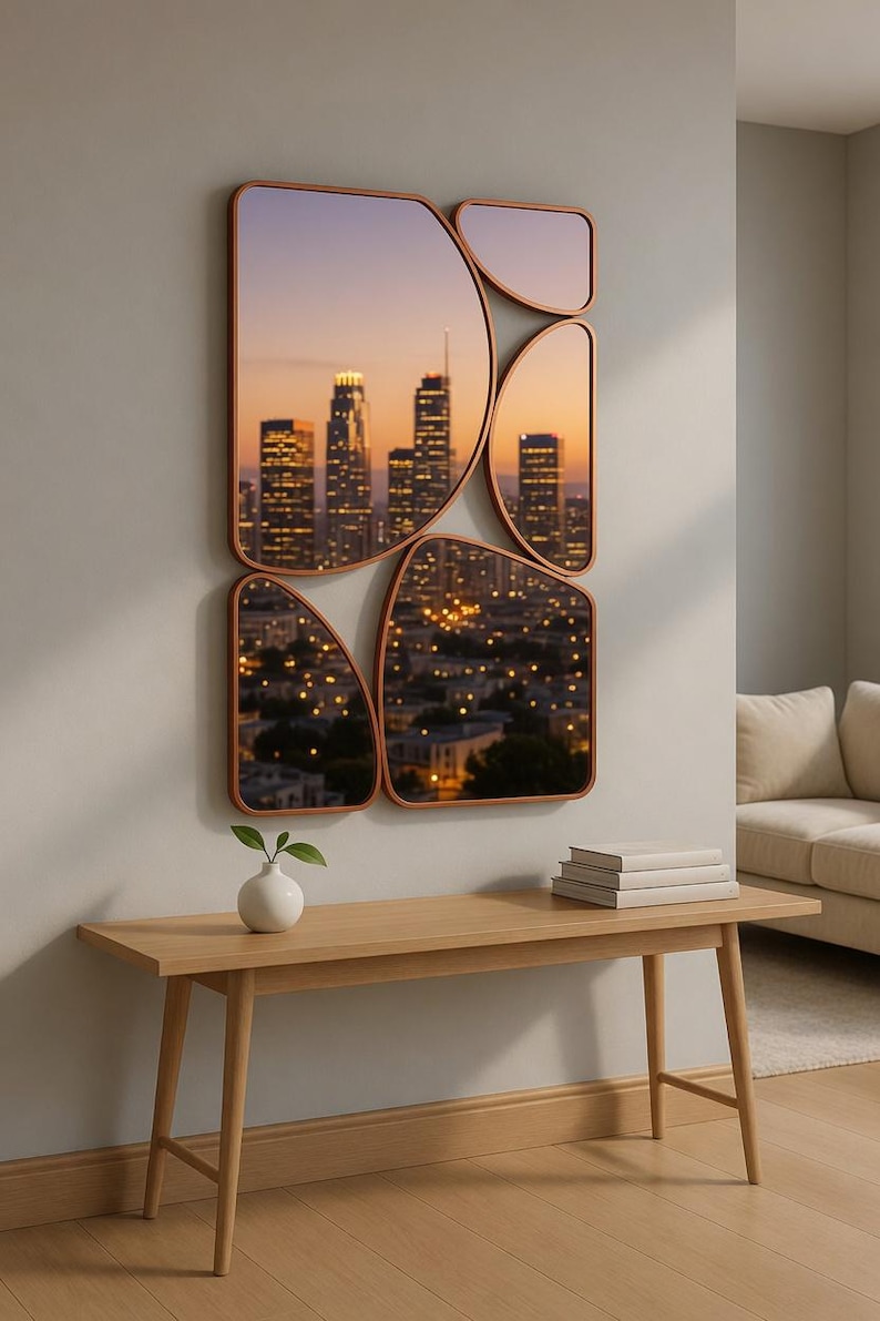 May include: A set of five copper-framed mirrors with an abstract design, each displaying a cityscape at dusk. The mirrors are mounted on a light gray wall above a wooden bench with a small white vase and books.