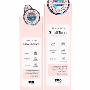 May include: Two light pink rectangular boxes of Dearboo Glass Skin Snail Serum and Snail Toner. The serum box is 100ml/3.38fl. oz. and the toner box is 250ml/8.45fl. oz. Both feature holographic circular labels with the text Glass Skin Natural Glow.