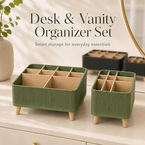 Puede incluir: Un juego de dos organizadores de escritorio y tocador en color verde oliva con paredes exteriores de textura acanalada vertical y patas de madera clara. El interior tiene divisores beige que crean múltiples compartimentos. Texto: Desk & Vanity Organizer Set.