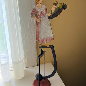 May include: A white ceramic mug with a black handle and the text "But First, Coffee" in a black, bold font. The mug is on a white surface. The mug is approximately 4 inches tall.