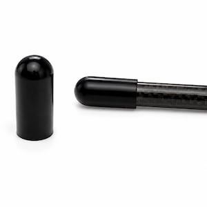 May include: A smooth, glossy black cylindrical end cap stands upright next to a carbon fibre rod. The rod features a visible woven pattern and is fitted with an identical black end cap on its tip, creating a clean, functional assembly.