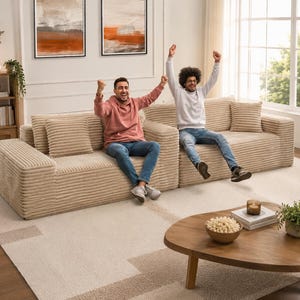 Puede incluir: Un sof&aacute; seccional de pana beige con cojines a juego. Dos personas est&aacute;n sentadas en el sof&aacute;, celebrando con los brazos levantados. Una mesa de centro de madera con un cuenco de palomitas y una planta est&aacute; frente al sof&aacute;.