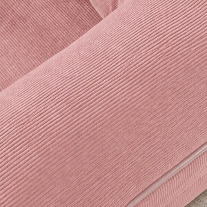 Puede incluir: Primer plano de una secci&oacute;n de un sof&aacute; de pana rosa. La tela tiene una textura acanalada, con las crestas que corren diagonalmente a trav&eacute;s del marco. Los bordes est&aacute;n ribeteados con una tuber&iacute;a rosa m&aacute;s clara.