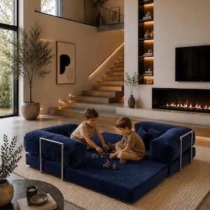 Puede incluir: Un sof&aacute; modular azul marino con detalles met&aacute;licos plateados. Dos ni&ntilde;os juegan en el sof&aacute;. El sof&aacute; est&aacute; sobre una alfombra beige en un sal&oacute;n moderno. La habitaci&oacute;n tiene chimenea, una ventana grande y una escalera.