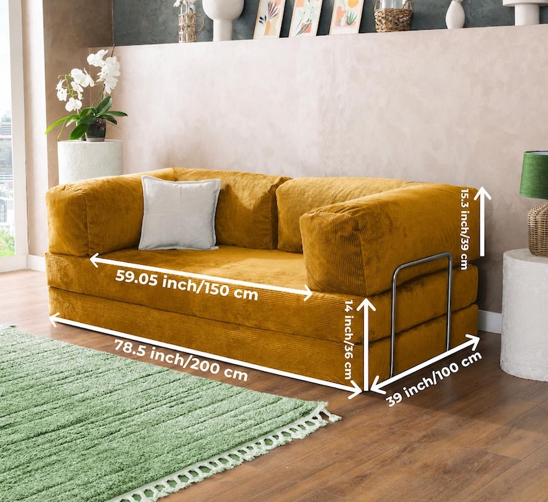 Puede incluir: Sof&aacute; de pana amarillo mostaza con un coj&iacute;n gris claro. El sof&aacute; mide 200 cm de largo, 150 cm de ancho y 100 cm de profundidad. Tiene una estructura met&aacute;lica y mide 39 cm de alto. Los reposabrazos miden 36 cm de alto.