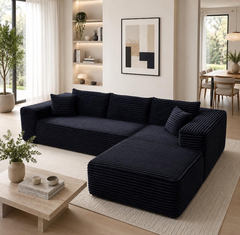 Puede incluir: Un sof&aacute; seccional azul marino con textura de pana. El sof&aacute; tiene m&uacute;ltiples cojines y un dise&ntilde;o en forma de L. Est&aacute; colocado sobre una alfombra de color claro en un sal&oacute;n moderno. Dimensiones aproximadas: 250 cm x 160 cm.