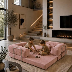 Puede incluir: Sal&oacute;n moderno con un gran sof&aacute; modular rosa. Dos ni&ntilde;os juegan en el sof&aacute;. La habitaci&oacute;n cuenta con chimenea, una ventana grande y una escalera. La decoraci&oacute;n es minimalista y neutra, con enfoque en la luz natural.