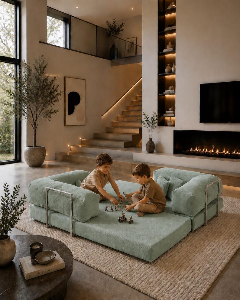 Puede incluir: Un sof&aacute; modular verde claro con detalles de marco met&aacute;lico. Dos ni&ntilde;os juegan en el sof&aacute;. El sof&aacute; est&aacute; sobre una alfombra beige en un sal&oacute;n moderno. La habitaci&oacute;n cuenta con chimenea, escalera y grandes ventanales.