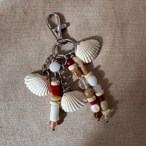 Ręcznie wykonany brelok do torebki z motywem muszli, koralikowy brelok w stylu boho z naturalnymi muszlami morskimi, plażowy dodatek do torebki, estetyczny brelok w kolorze czerwonym i białym