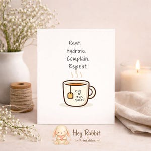 May include: A white greeting card with the text "Rest. Hydrate. Complain. Repeat." features a cartoon teacup with the words "Cup o' This Sucks." A small bunny holding a heart is at the bottom, with "Hey Rabbit Printables" below.