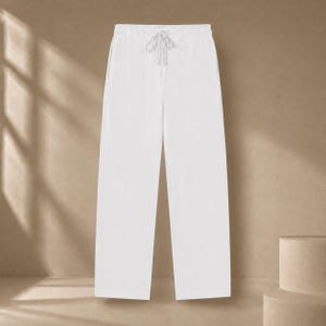 Könnte beinhalten: Einfarbige weiße Hose mit geradem Beinverlauf, elastischem Bund und einem passenden weißen Kordelzug in der Mitte. Die Hose zeichnet sich durch ein schlichtes, klares Design und eine durchgehend blickdichte, weiße Farbgebung aus.