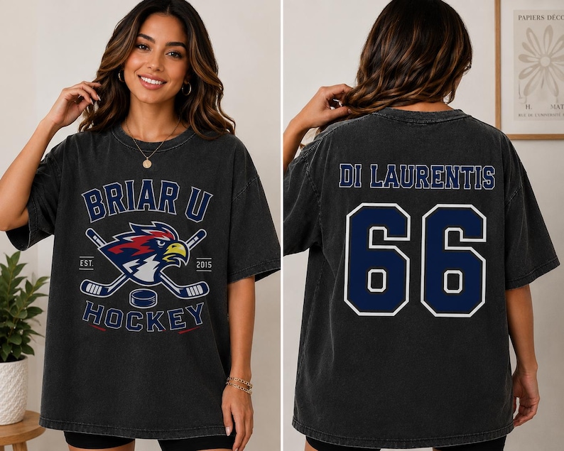 Puede incluir: Camiseta gris oscuro con dise&ntilde;o de hockey, con el texto "Briar U Hockey" y un logotipo de p&aacute;jaro y palos de hockey cruzados. La parte trasera muestra el nombre "Di Laurentis" y el n&uacute;mero "66" en azul marino.