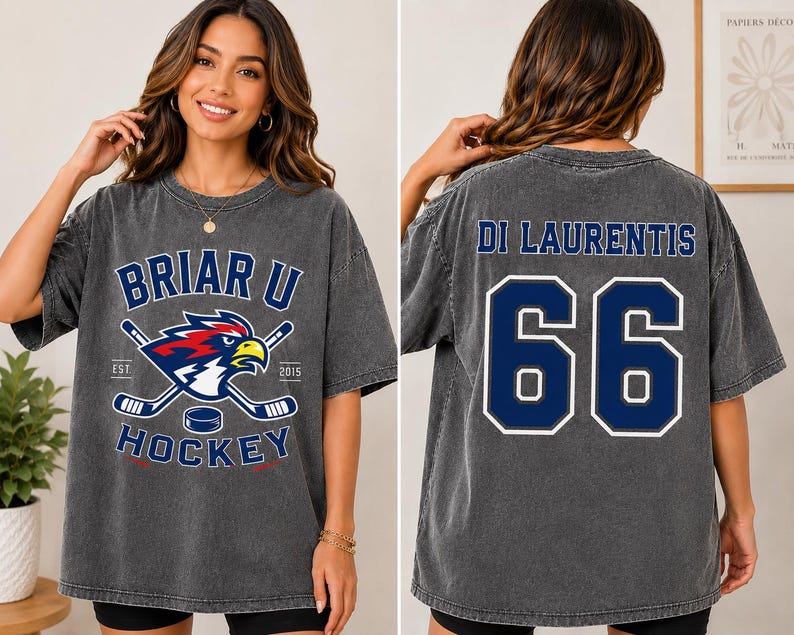 Puede incluir: Camiseta gris oscuro con el texto "Briar U Hockey" y logotipo en la parte delantera, con palos de hockey cruzados, un disco y un &aacute;guila estilizada. La parte trasera muestra "Di Laurentis" y el n&uacute;mero "66" en azul.