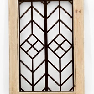May include: A rectangular wooden framed wall decor. The interior features a geometric design in black against a white background. The design is composed of angular lines and shapes, creating a modern aesthetic.