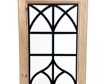 May include: A rectangular wooden framed wall decor piece with a black geometric design on a white background. The frame is made of light-colored wood, and the black design features arched and angular shapes.