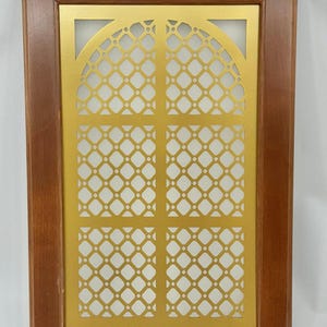 May include: A decorative wooden frame with a gold-coloured, lattice-patterned insert. The insert features a repeating diamond design and an arched top. The frame is a medium brown colour.